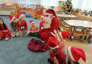 Mikołaj rozdaje dzieciom książki o Koziołku Matołku.